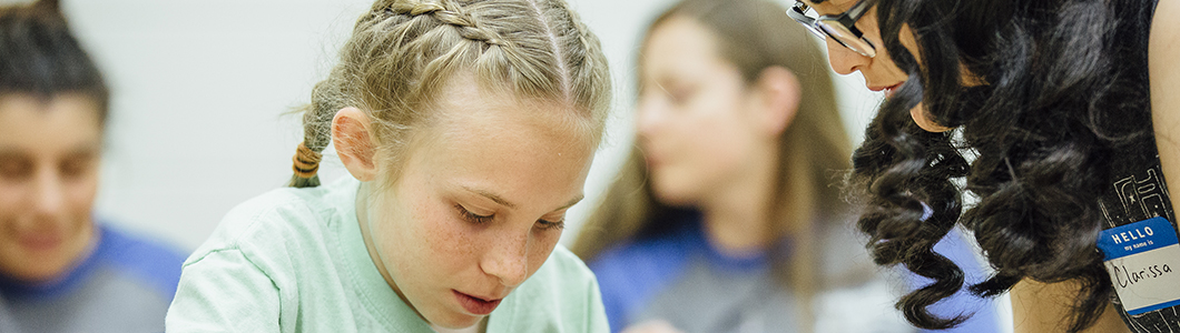 A student teacher helps a student with a problem.