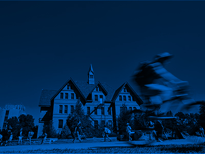 A student bikes past Montana Hall.