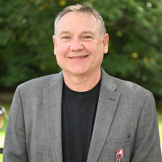 Dr. Michael Johnson wears a suit jacket and stands outside.