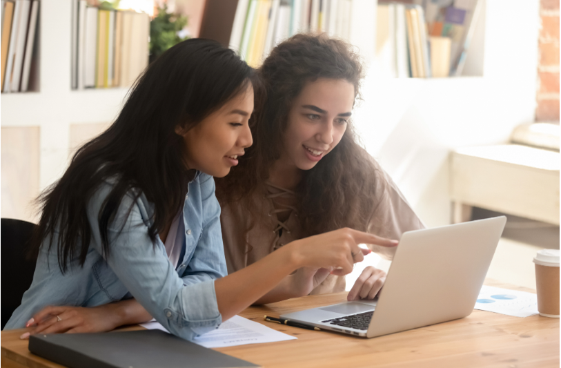 Girls smiling and looking at laptop computer
