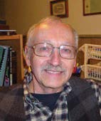 Headshot of a man with grey hair and glasses.