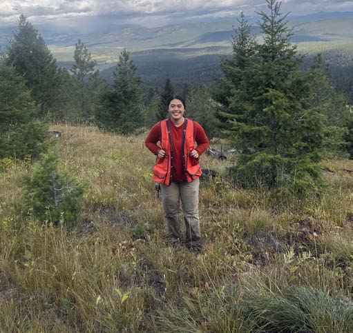 Image of Lexi Smith in a forest with an orange vest.