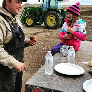 Family eating dinner on tailgate of truck