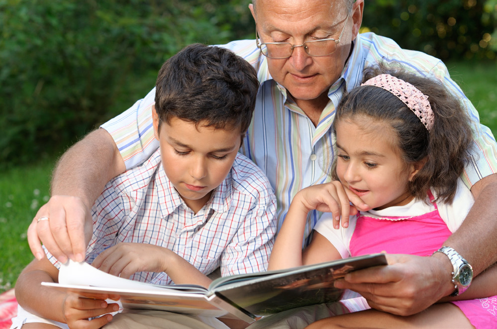 A man reading to two children.