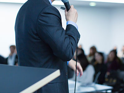 the back of a speaker talking at a podium 