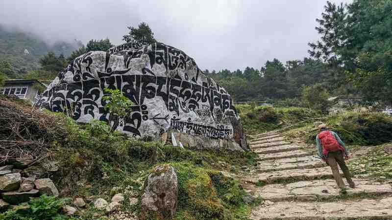 A rock formation with painted symbols alongg the hillside 