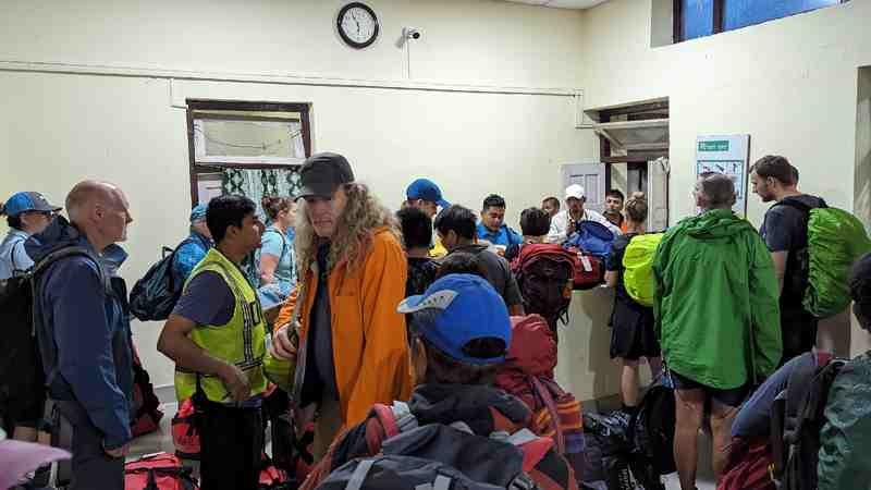 The group stands in the airport waiting to board their flight.