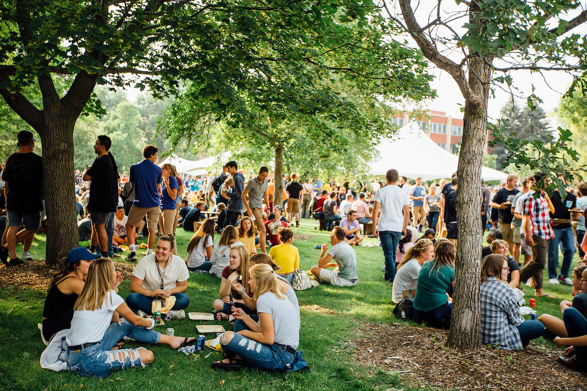 new students eating food on the grass outside