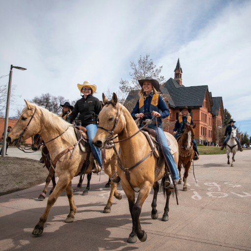 students riding horses on campus