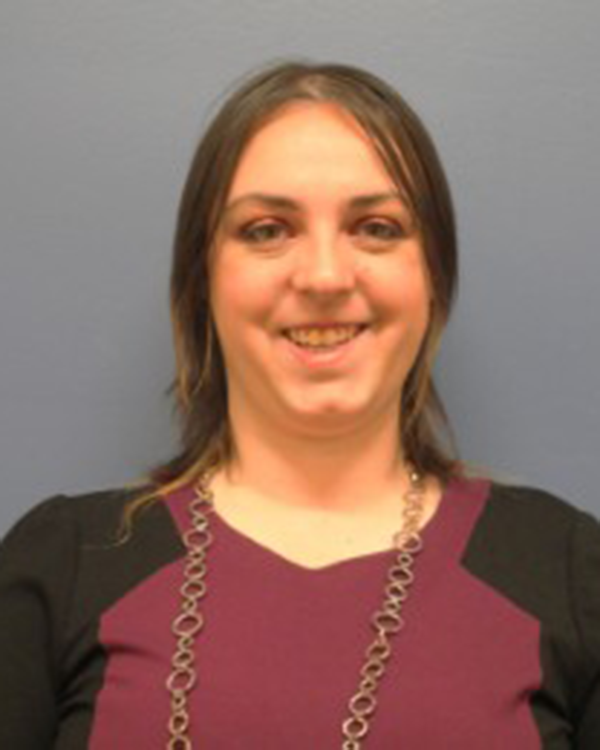 A person wearing a red and black long sleeved shirt and a necklace