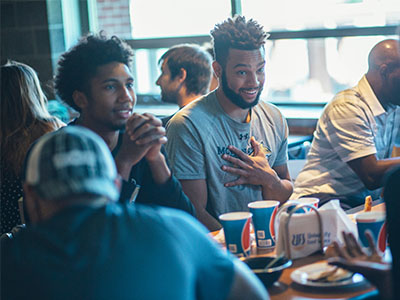 Students talking at a table in a dining hall.